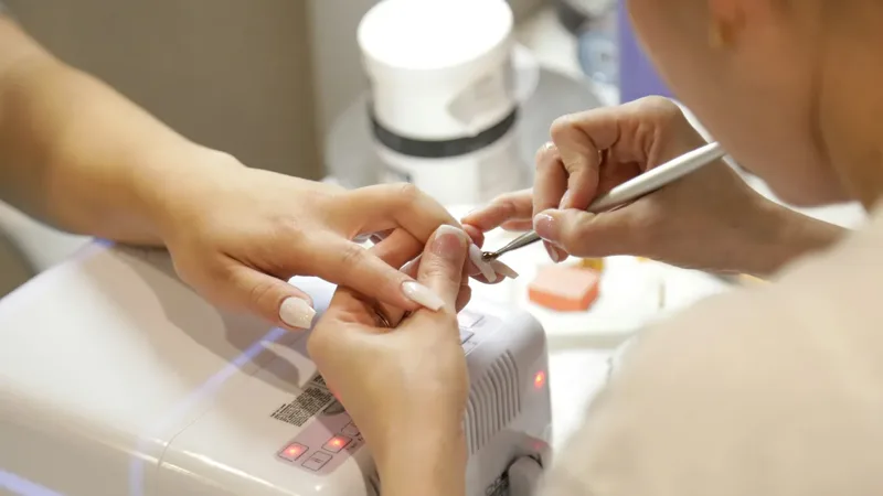Nail technician doing detailed cuticle work during a manicure at Urban Glam salon Dubai